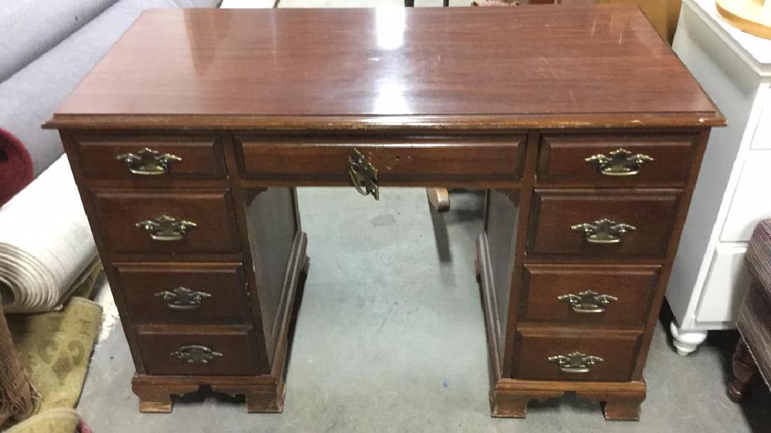 Wood and Brass 7 Drawer Home Office Desk: Wooden 7 Drawer Office Desk. Contains Gold toned handles. Some surface wear and chips, middle drawer handle needs to be repaired. Bottom appears to be carved. Office desk, Executive desk, Home office