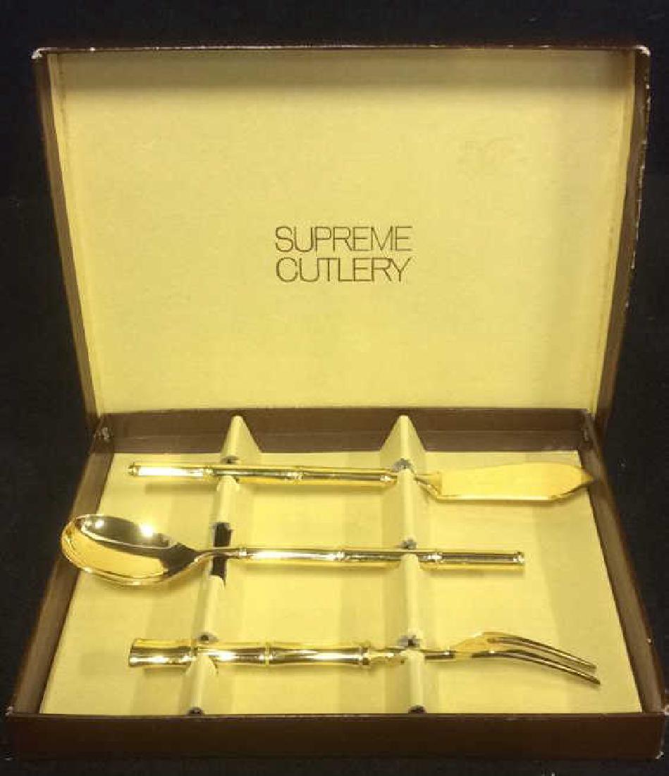 Lot 3 SUPREME CUTLERY Vermeil Utensils w Box: Includes vermeil 2 pronged fork, cheese knife, and spoon. Comes in box marked SUPREME CUTLERY. Vermeil Utensils, Tabletop Utensils, Gold toned utensils. Box measures approx 8 inches long 6.5 inches wi