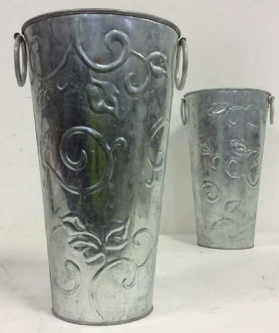 Pair PIER 1 Dual Handled Planters: 2 PIER 1 Silver toned dual handled planters, vases, with beveled leaf and vine detail. Planters, Handled planters, metal planters. table decor, Measures approx 14 inches tall 8 inches diameter.
