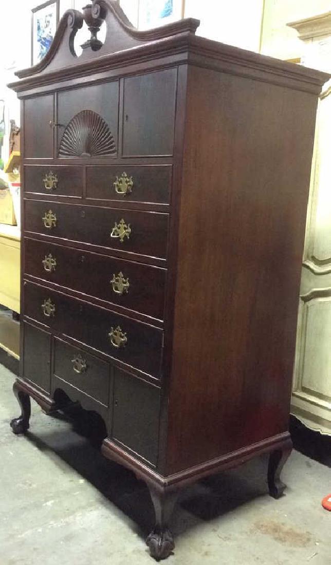 Mahogany Toned Carved Wooden Chest: Sheraton style, highboy, Mahogany Toned Carved Wooden Chest. Contains carved wooden ball and claw feet, crown with finials, cabriolet feet, ornate gold toned handles, skeleton key, 6 lockable drawers,