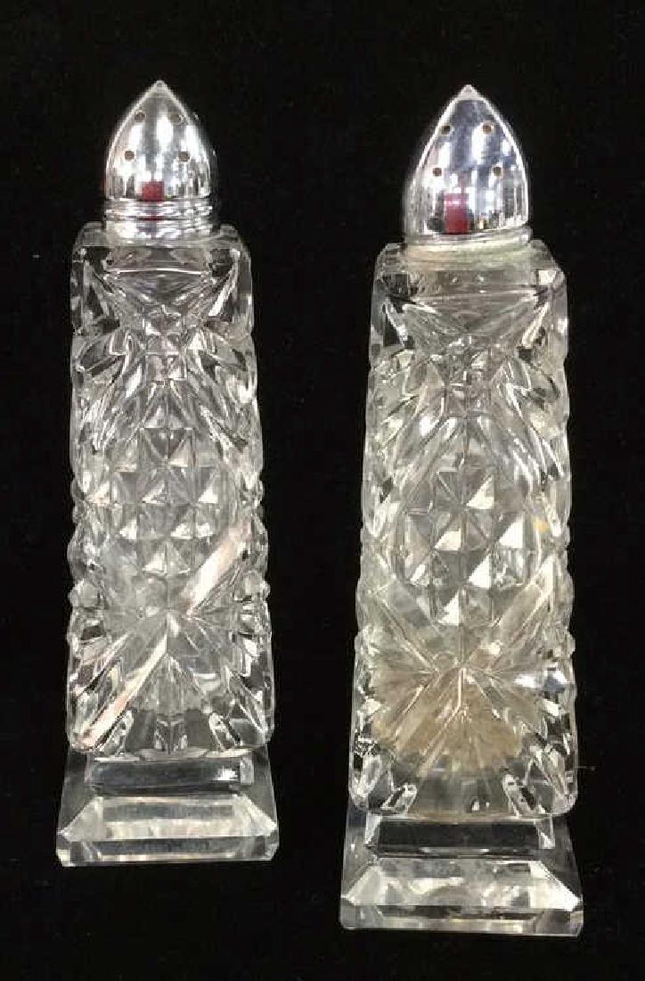 Pair Cut Glass Geometric Cut Salt&Pepper Shakers: Pair Cut Glass Geometric Cut Salt&Pepper Shakers. Cut glass, possibly crystal salt and pepper shakers with silver toned metal tops. Some oxidation on tops. Measures approx 6 in tall 2 in wide by 2 in