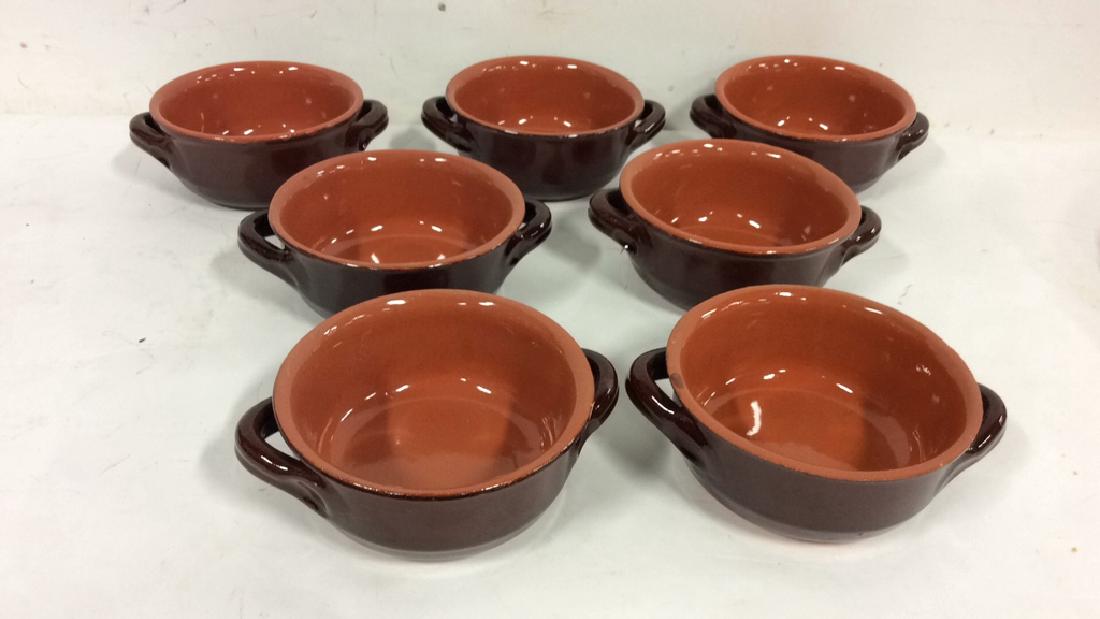 Lot 7 Brown Stoneware Handled Bowls: Lot 7 Brown Stoneware Handled Bowls. Stoneware, earthenware, ceramic soup or dessert bowls. Marked illegibly on bottom. Two toned, brown dishes. Measures approx 3 in tall by 7 in long by 6 in wide.