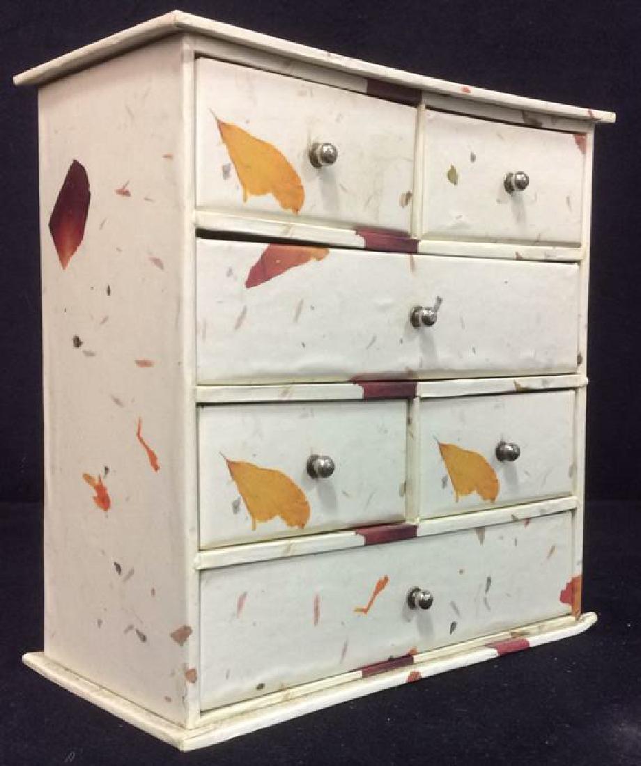 Cream Toned Sampler Jewelry Box: Cream Toned Sampler Drawer Jewelry Box contains orange and red olive toned strokes. Contains 6 compartments with silver toned knob style handles. Measures approx 8 inches tall, 8 inches, 4 inches deep