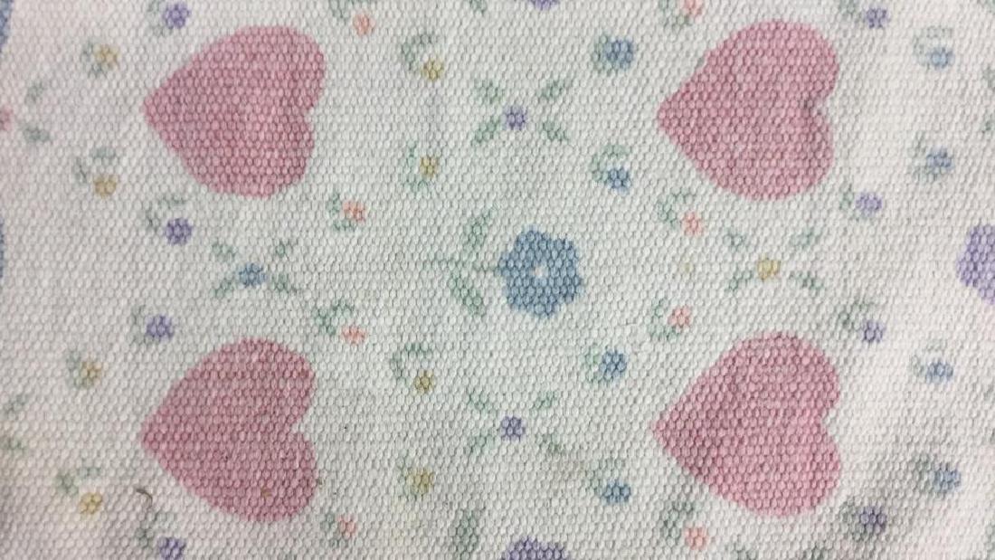 Woven Cotton Rug W Heart and Flower Motif: Woven Cotton Rug W Heart and Flower Motif and fringe on two edges. Decorative pattern of pink hearts and multi colored flowers. No condition issues noted. Measures approx 20 inches l x 25 inches w.