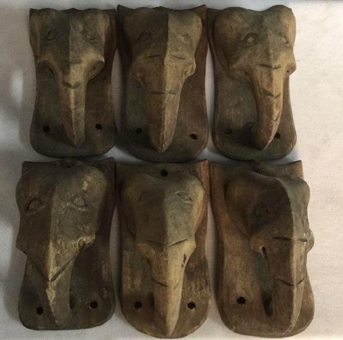 Lot 6 Carved Wooden Elephant Wall Mounts: 6 Carved Wooden Elephant Wall Mounts. Contains carved facial details with 3 holes in each for wall fastening. Each Measures approx 4 inches tall 2 inches wide and deep.