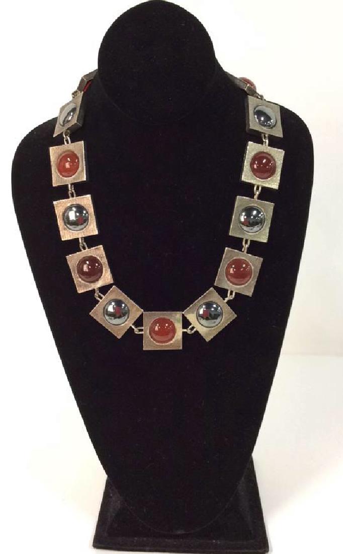 Scandinavian Modern Brutalist Necklace c.1960s: Scandinavian Modern Brutalist Necklace c.1960s. Silver metal toned square brackets with silver metallic centers and rust toned possible carnelium natural stone pieces. Measures approx 10 in long. Esta