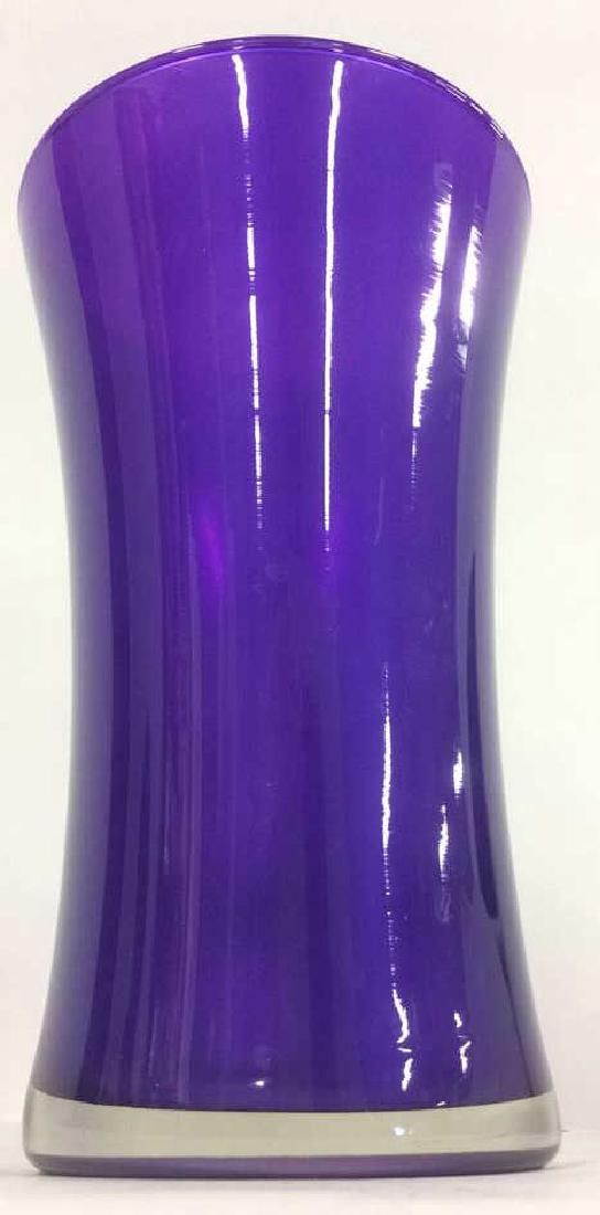 Glass Purple Toned Vase: Round Glass Purple Toned Vase. Vase contains hourglass like figure. Measures approx 9 inches tall 5 inches diameter.