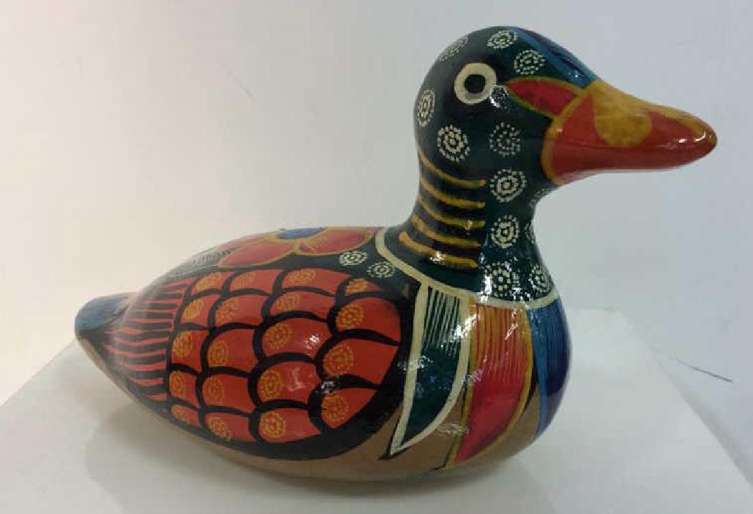 Earthenware Multicolored Painted Duck Statuette: Earthenware Multicolored Painted Duck Statuette. Hollow figurine, brightly colored paint, floral and geometric patterns. Measures approx 5 in tall by 8 in long by 4 in wide.
