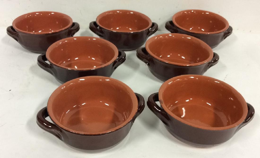 Lot 7 Brown Stoneware Handled Bowls Tabletop: Lot 7 Brown Stoneware Handled Bowls. Stoneware, earthenware, ceramic soup or dessert bowls. Marked illegibly on bottom. Two toned, brown dishes. Measures approx 3 in tall by 7 in long by 6 in wide.