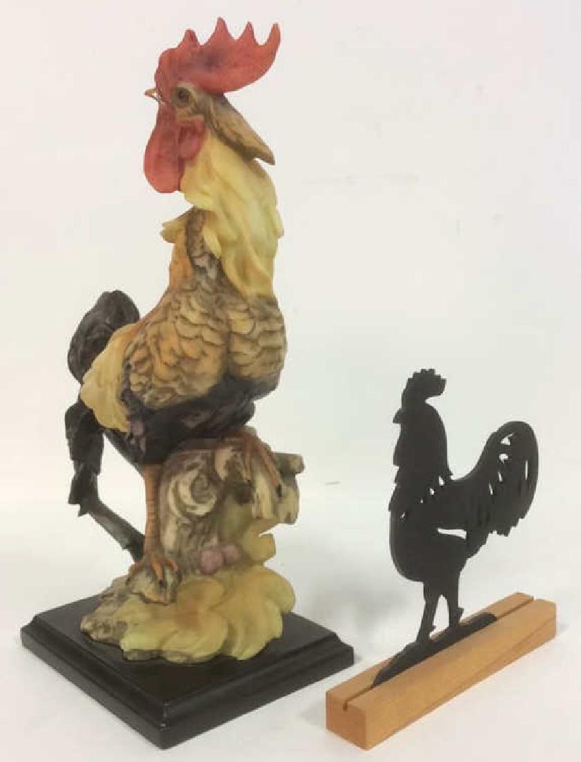 Lot 2 Rooster Figurals: Includes 1 plaster figural with dark brown toned wooden base 1 flat rooster figural with pierced detail. Plaster Rooster measures approx 12 inches tall 7.5 inches long.