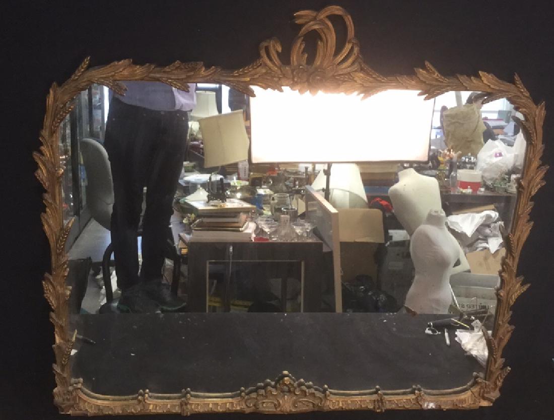 Antique Ornate Carved Gilded Mantle Mirror: Antique Ornate Buffet Mantle Mirror with floral, wheat, and scroll designed frame. Frame is painted in gold toned paint with red highlights. Damage to some wheat stalks, cracks throughout and damage t