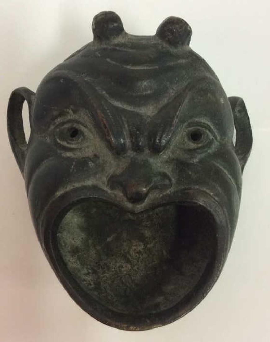 Gargoyle Face Figural Green Trinket Dish: Face Figural Trinket Dish. Horned Caricature face with open mouth, appears to be a trinket dish. Dark brass toned metal some surface wear and oxidation on piece. Measures approx 3 1/2 in long by 3 in 