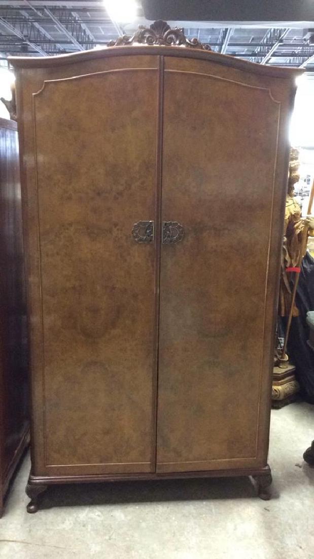 Carved Burled Wood Armoire Closet: Front Doors have burled wooden detail. Handles are gold toned with ornate detail. Interior contains closet space with hanging rod, 2 drawers, and 4 flip down door compartments. Top contains ornately c