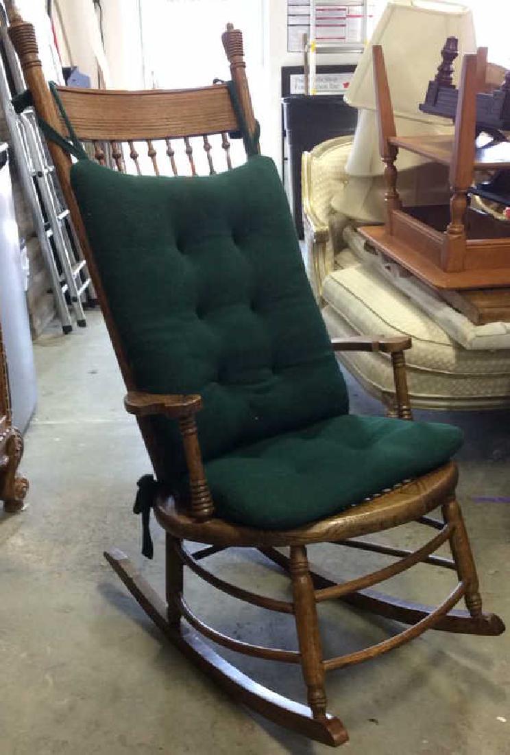 Caned Carved Wooden Rocking Chair: Vintage possibly antique, Contains carved wooden detail and spindle style backrest. Seat under cushion has caning. Includes green toned seat and back cushion. Contain some minor chips & scratches. Mea