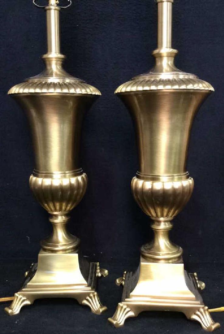 Pair Filigree Brass Toned Metal Lamps: Pair Filigree Brass Toned Metal Lamps. Pair urn figural brass toned metal lamps with brass toned metal clawed foot style base. Measures approx 33 in tall by 7 in in diameter.