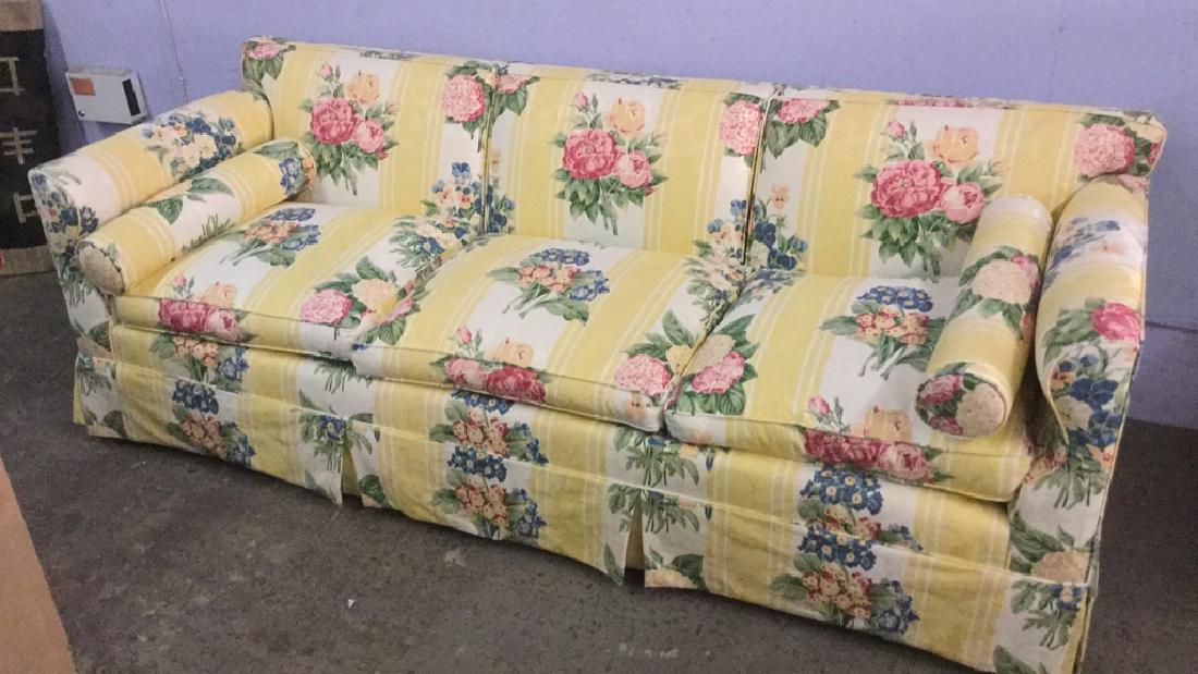 Three Seat Sofa With Floral Upholstery: Three Seat Sofa With Floral Upholstery. Upholstered sofa with yellow stripes and red and blue floral motif. Has some surface dirt. Measures approx 85 inches wide x 32 inches deep x 26 inches tall. pro