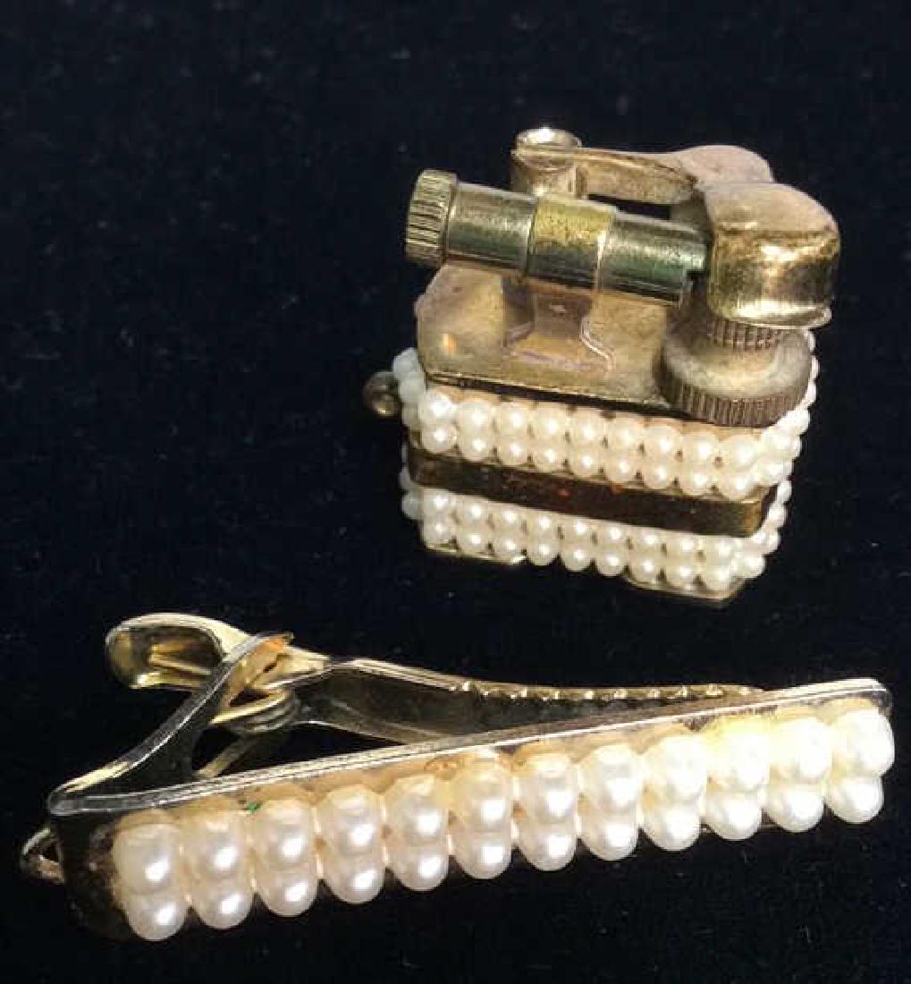 Lot 2 Vintage Faux Pearl Lighter W Tie Clip: Lot 2 Vintage Faux Pearl Lighter W Tie Clip. Vintage pendant lighter and matching tie clip with faux seed pearl details and brass toned body, some minor discoloration on metal. Lighter marked as pat #