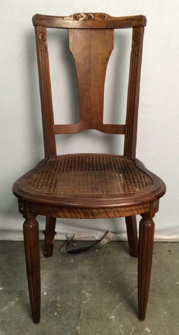 Carved Wooden Chair W Caned Seat: Top of backrest has carved wooden floral detail. Top of front 2 legs have gold toned floral detailed accents. Seat is caned. Contains some minor surface frame and very minor wear. Measures approx 36 i