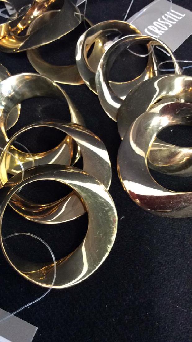 Lot 12 CROSCILL Gold Toned Metal Napkin Rings: Lot 12 CROSCILL Gold Toned Metal Napkin Rings. Tags read CROSCILL, originally purchased at Bloomingdales. Measures approx 2 in in diameter.