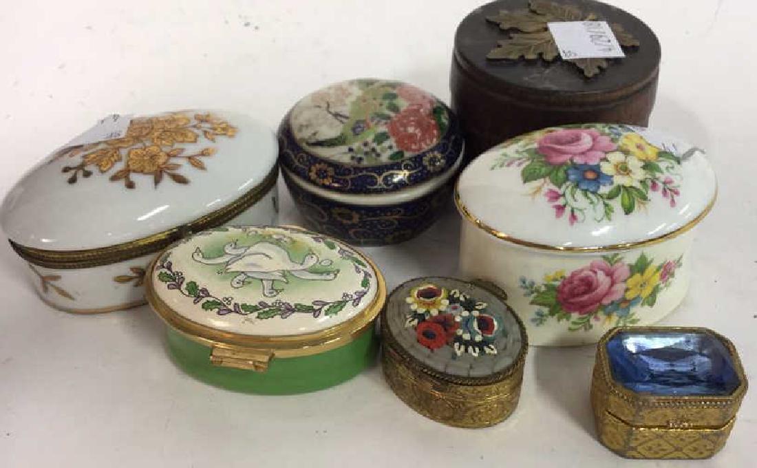 Group Lot 7 Lidded Pill Boxes, Porcelain and more: Largest wood with oak leaf measures ht app 2 inches; one in chinoiserie style; mosaic inlay in brass made in Italy, gold painted white porcelain brass trim border closure, one marked Staffordshire Eng