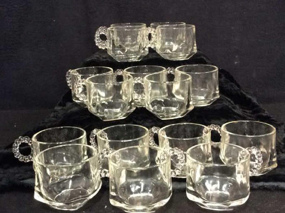 Set 16 Pressed Glass Handled Punch Cups: Set 16 Pressed Glass Punch Cups. Square bodies with circular orb handles. Measures approx 2 1/2 in tall by 4 in long by 3 in wide .Candle Wick Collectible Glass, Mugs, Cups,