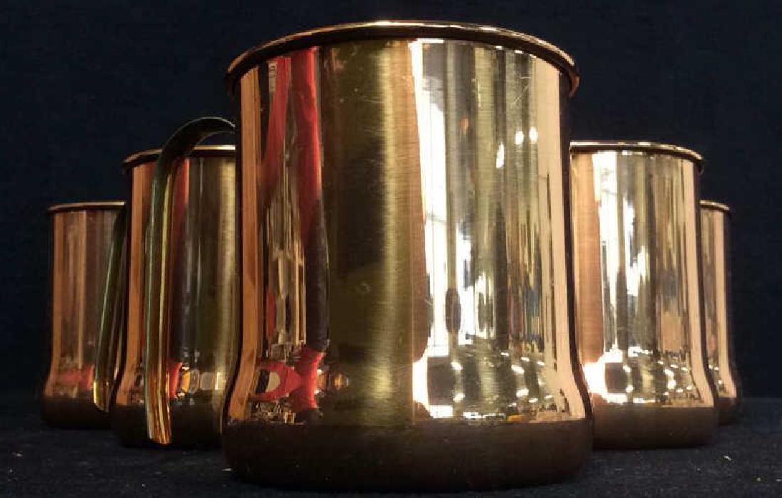 Lot 6 Copper Toned Cups W Handles: Lot 6 includes 6 copper toned cups with gold toned handles. Each measures approx 3.5 inches tall 4.5 inches wide with handle. Some have minor scratches. Comes in original box.