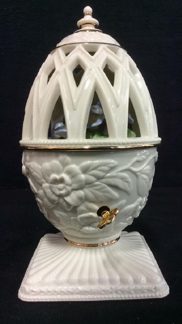 LENOX Spring Musical Porcelain Egg: Piece is marked SPRING MUSICAL EGG COLLECTION LENOX. Piece is cream toned. Contains gold toned accents and dial. Piece has beveled floral detail. Lid has pierced detail. Inside contains a depiction of