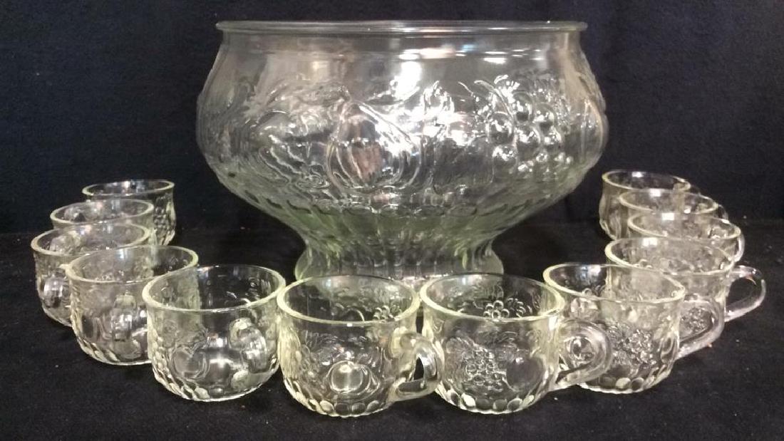 Lot 13 Fruit Detailed Punch Bowl & Cups: Lot Includes 1 glass punch bowl with beveled fruit detail and 12 matching glass cups with handles. Bowl measures approx 7.5 inches tall 12 inches wide. Set is in good condition only contains minor wea