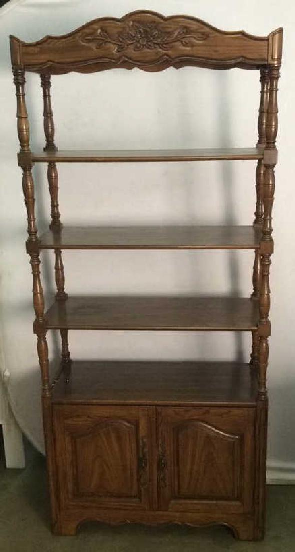Carved Wooden What not Display Shelf: Contains carved florals detail at top. Piece has 3 shelves. Lower area has cabinet space cabinet. Cabinet doors have dark gold toned metal handles. Bottom shelf is detachable. Piece is brown toned . M