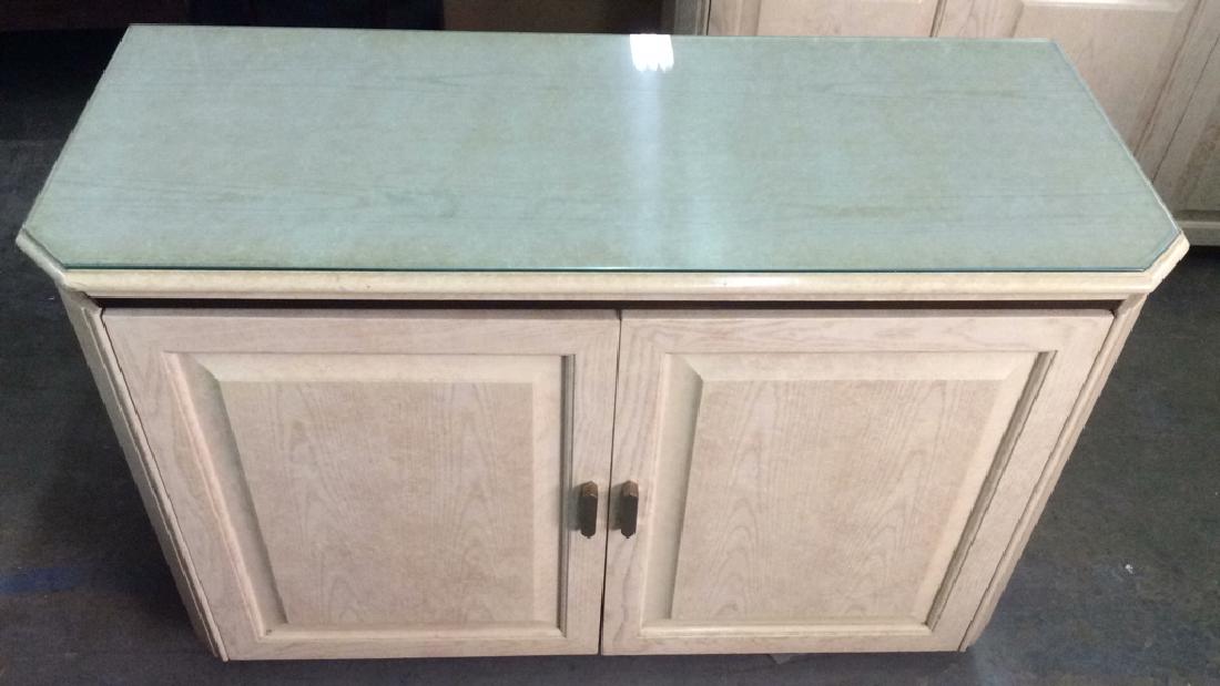 HENREDON Cream Toned Counter Bar-top: HENREDON cream toned counter bar-top contains a sheet of glass that rests on top of surface of counter. Contains two doors with gold toned handles with a shelf inside along with two sliding drawers an