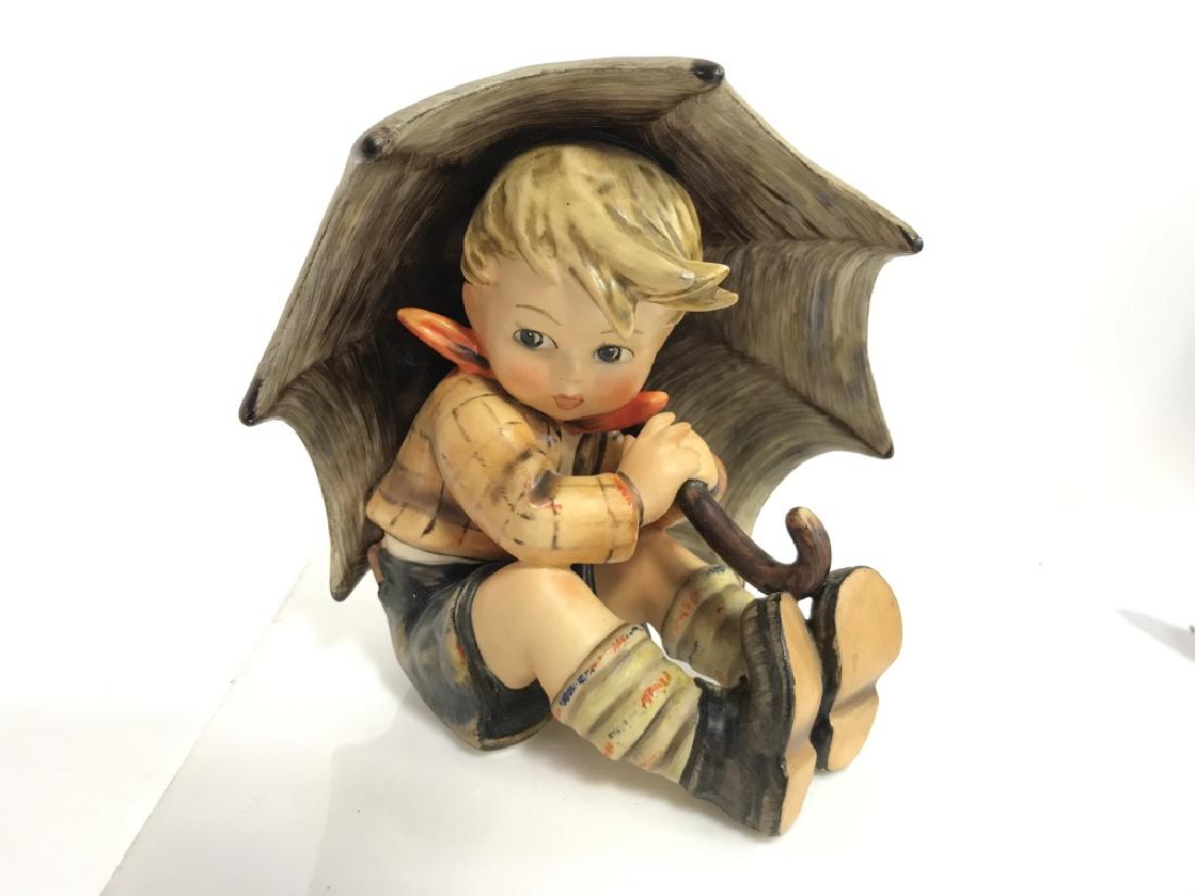 GOEBEL Hummel Boy w Umbrella: GOEBEL Hummel Boy w Umbrella. Painted porcelain figurines of boy with umbrella. Good condition, very minor surface wear, minor chip on underside. Signed on umbrella, bottom reads GOEBEL. Measures appr