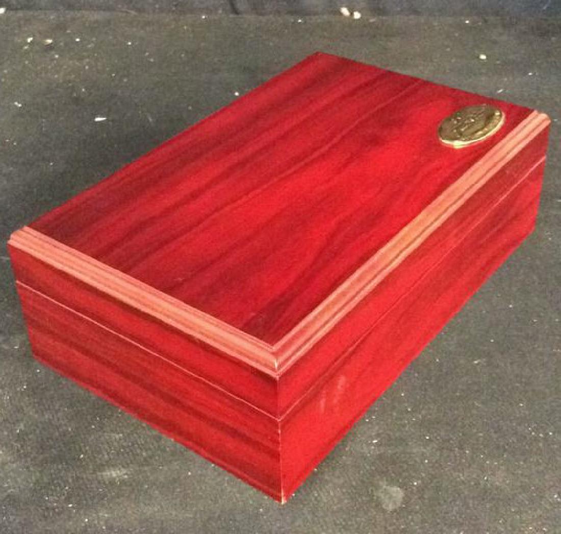 Red Toned A Aldo Velani Wooden Box W pipe: Red toned A Aldo Velani wooden box from the Millennium Collection contains a gold toned emblem on the bottom right side of the lid. Inside contains a velvet like material with two Fitted Slots outline