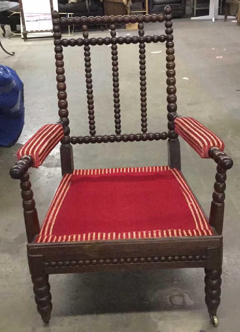 English Bobbin Wood Carved Armchair: Bobbin chair has carved wooden detail. Cushion is striped with tones of red and gold. Cushions are loose and tufted. Measures approx 37 inches tall 27 inches wide, 33 inches deep. Needs minor tighteni