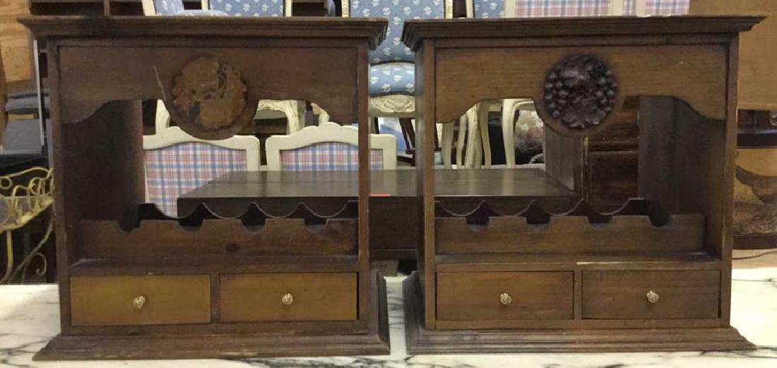 Lot 2 Carved Wooden Wine Rack Tables: Vintage Carved tables, possibly antique, Each Table has 4 wine bottle spaces. Both have 2 small drawers with gold toned metal knob style handles. One piece has intricately carved grape leaf and vine d
