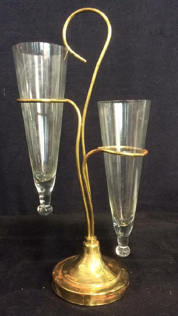 2 Arm Gold Toned Metal & Glass Vase: Vase is gold toned, possibly brass. Contains 2 cone shaped glass sections. Measures approx 15 inches tall 7 inches wide.
