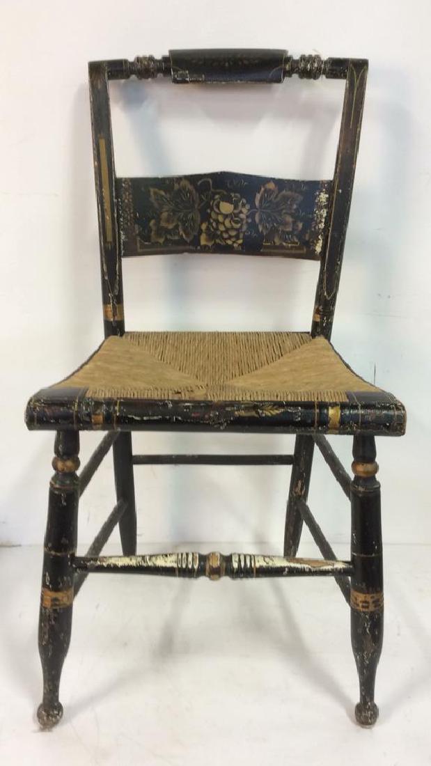 Vintage Carved Wooden HITCHCOCK Chair: Contains painted grape leaf and vine in gold toned detail. Contains rush seat. Piece is black toned with gold toned accents. Possibly antique. Contains stenciled detail. Has evident wear consistent wi