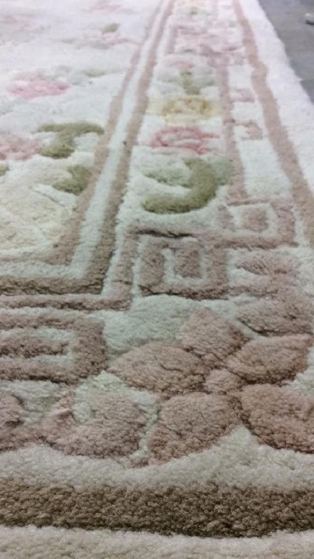 CHANG Wool Pile Cream Toned Floral Detailed Rug: Fringe Rug CHANG wool pile fringe rug. Cream toned with pink, yellow, green, purple, and sage toned floral detailing. Needs cleaning, overall good condition fringe partially detached. Fringe Rug, area