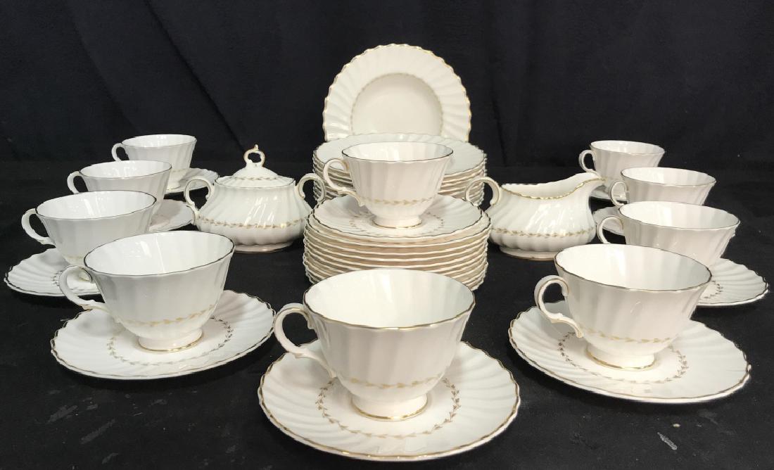 Lot 41 ROYAL DOULTON Partial China Set: Underside reads ROYAL DOULTON ENGLISH FINE BONE CHINA ADRIAN. Pieces have gold toned rims with gold toned leaf and vine detail. Soup bowls measure approx 8 inches diameter, 1.5 inches deep. Porcelain 