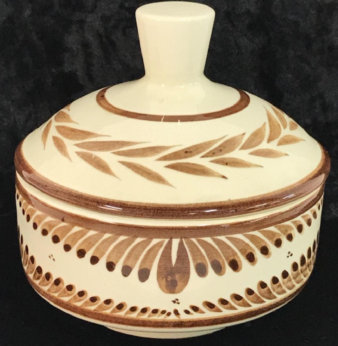 Painted Cream & Brown Ceramic Bowl w Lid: Ceramic bowl with lid is cream with brown toned painting. Bowl is designed with leaf detail. Bottom appears to read NOE SUAO MEX. DER A MANO. Contains some discoloring. Measures approx 5 inches tall x