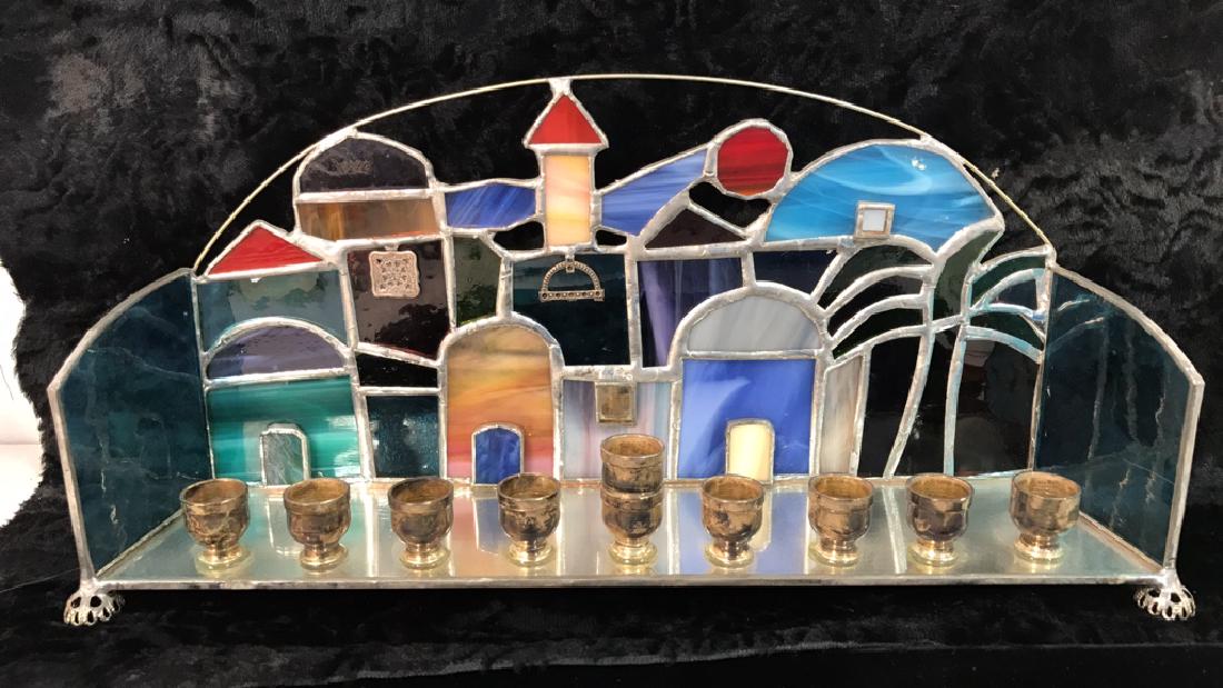 Stained Glass Jerusalem Rooftops Skyline Menorah: Stained glass Jerusalem rooftops skyline Chanukah menorah. Multicolored including red, orange, purple, and various tones of blue. Judaica, religious, Chanukah. Measures approx 7 inches tall x 14 inche
