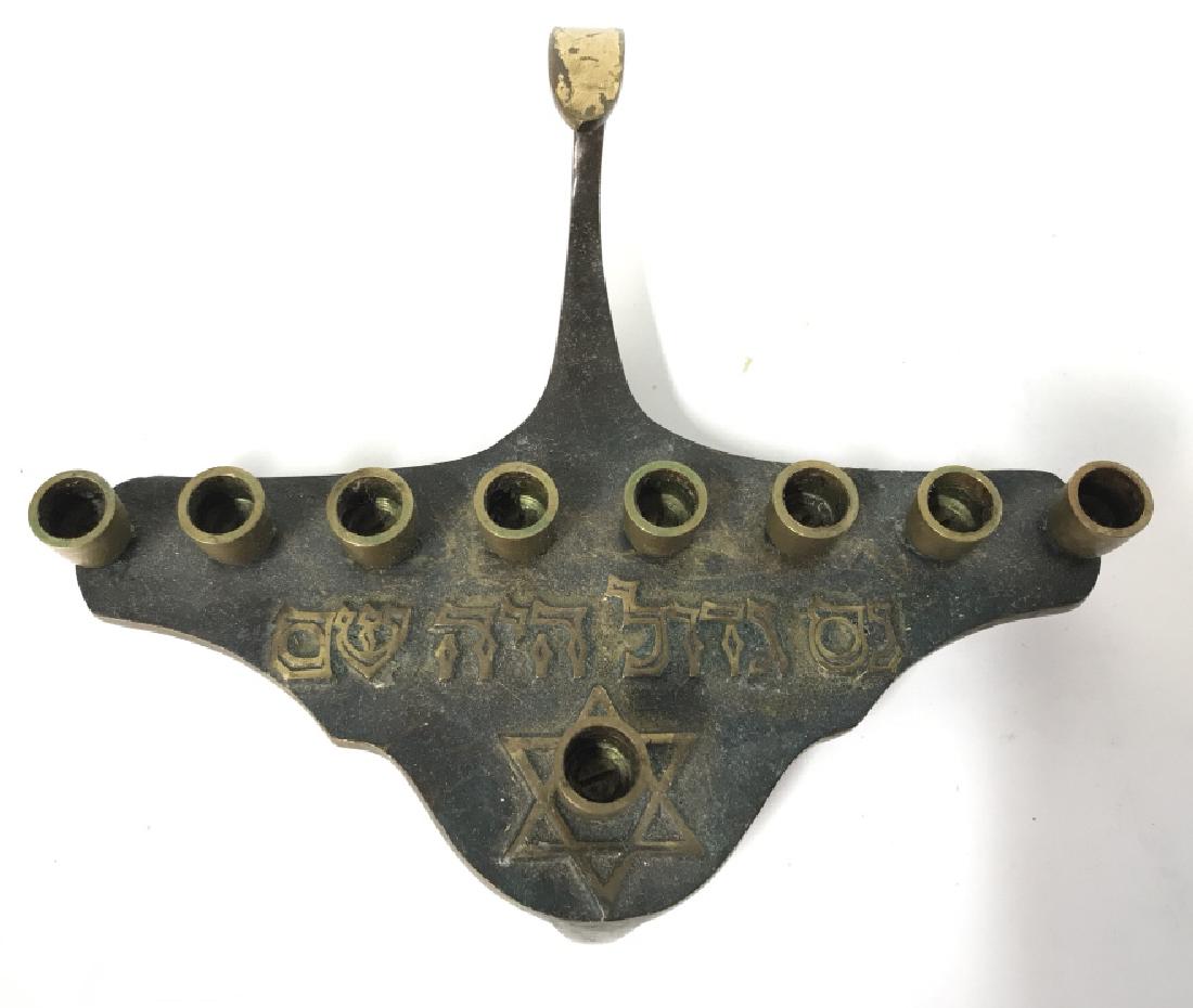 Gold Toned Poss Brass Judaica Menorah: Menorah appears to possibly be brass. Has Star of David detail and Hebrew characters. Reads MADE IS ISRAEL on underside. Measures approx 6.5 inches long 5 inches deep 2.5 inches tall. Judaica, ceremon