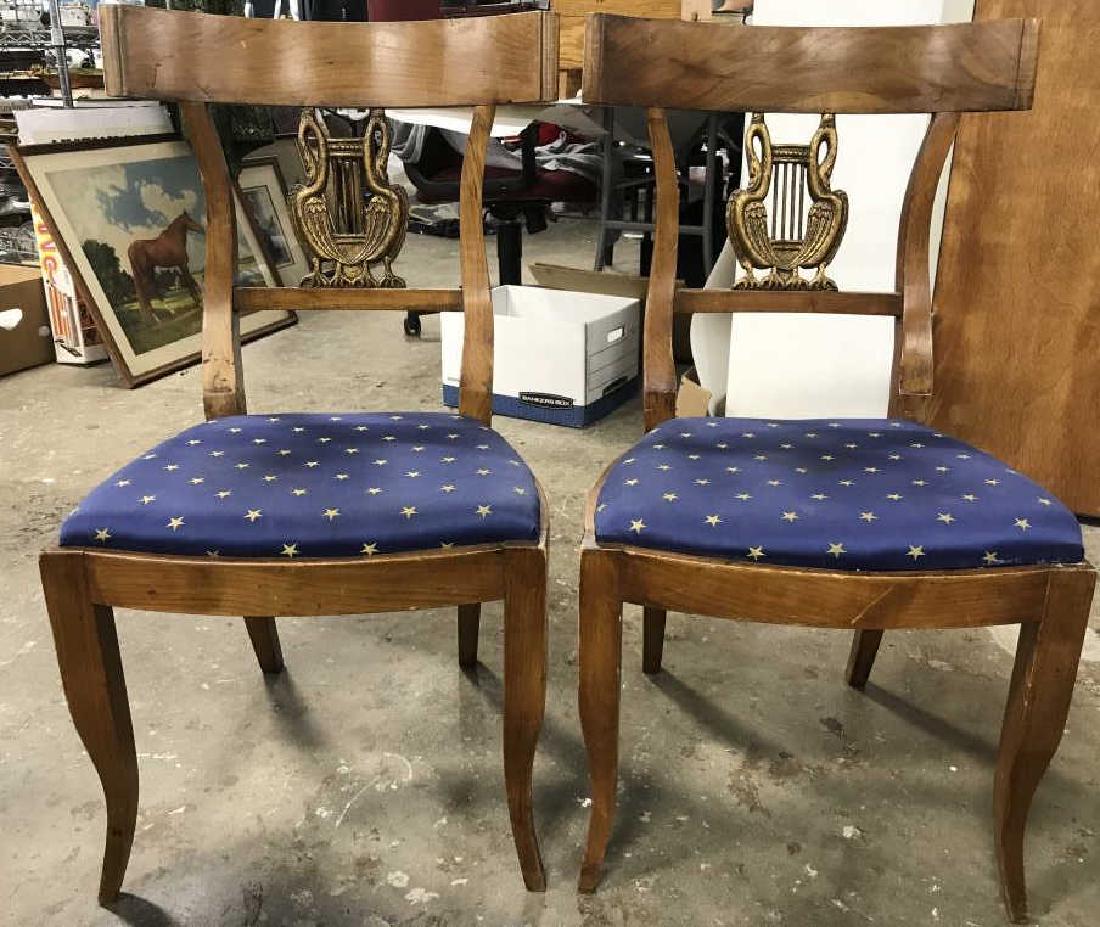 Pair Vintage Carved Wooden Chairs: Backrest of each has gold toned bird & harp like detail. Seat cushions are Upholstered with blue toned fabric with gold toned star pattern. Has some stains needs cleaning. Part of one backrest has chi