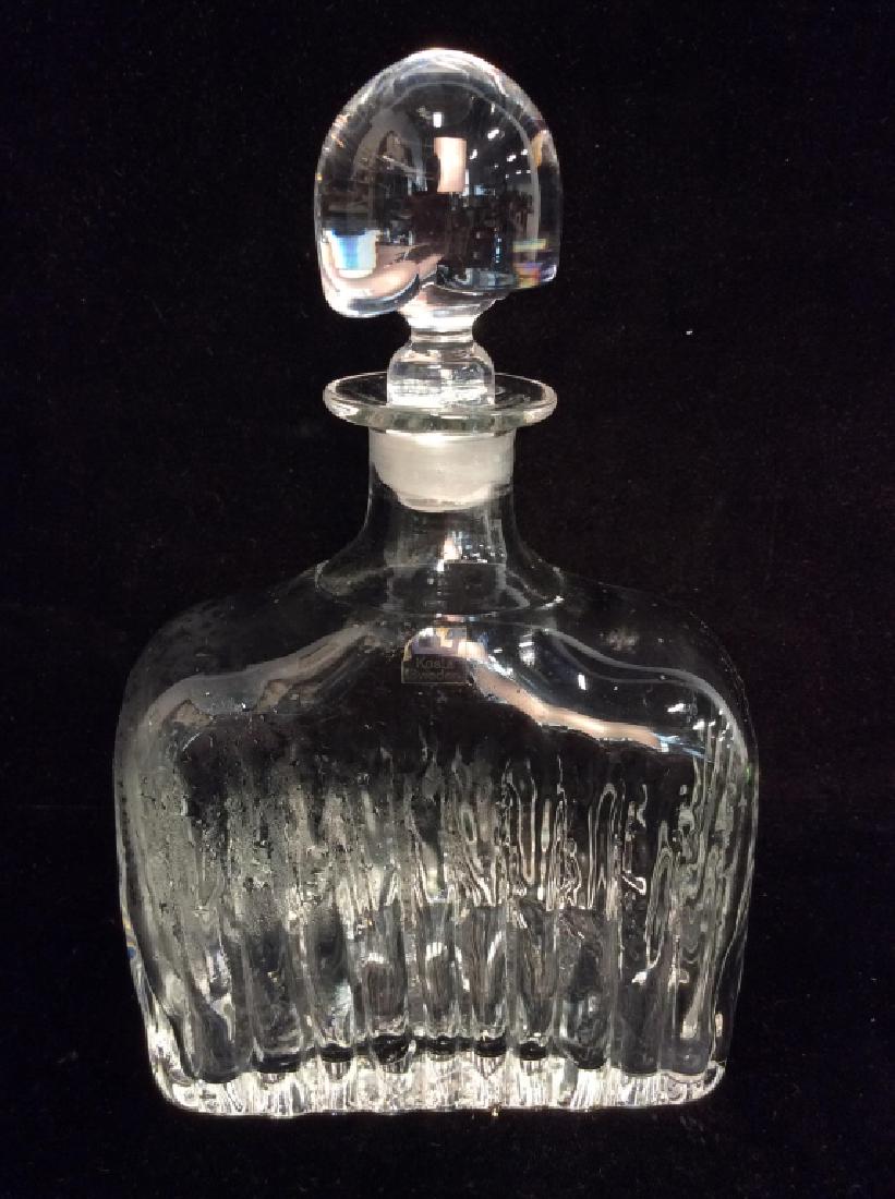 KOSTA BODA Glass Decanters W Stopper: KOSTA BODA Glass Decanters W Stopper. Textured sides and asymmetrical design stopper. Measures approx 9 inches tall 5 1/2 inches long by 2 1/2 in wide. decanter, home decor, tabletop accesory, table t