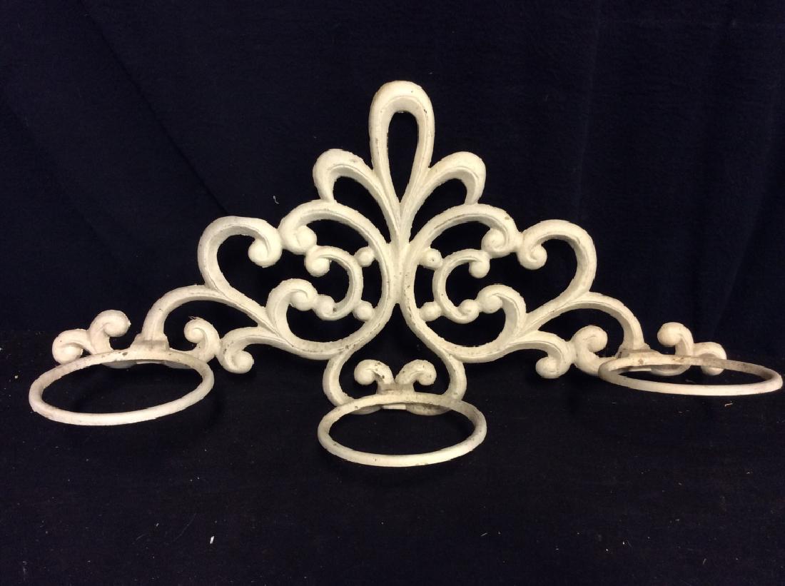 Wall Mounted Filigree Motif Plant Stand: Wall Mounted Filigree Motif Plant Stan. White toned painted weathered metal wall hanging, filigree design, three rings for plants. Possibly cast iron. Some minor surface wear. Measures approx 13 in ta