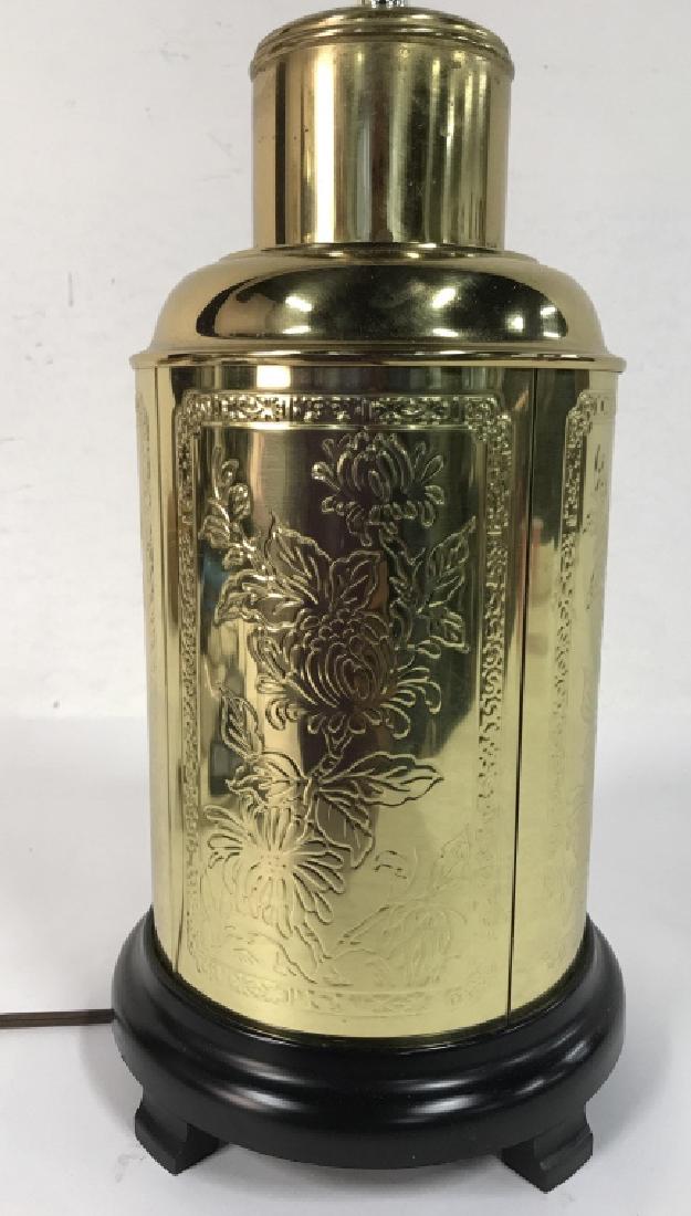 Gold Toned Metal Oriental Lamp: Lamp is gold toned with black toned base. Measures approx 25 inches tall 7 inches wide. Contains floral and leaf relief detail. Contains minor wear. Lamp, vintage lighting, home decor.