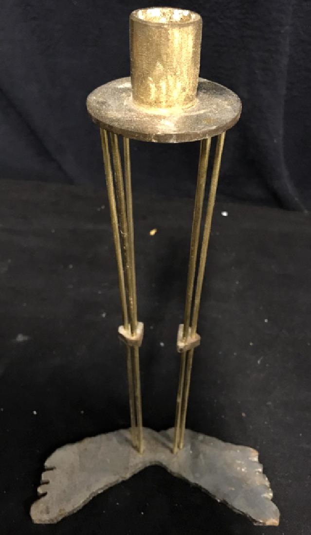 Metal Feet & Legs Candleholder: Metal candleholder contains silver toned feet with gold toned metal legs a circular base for the candle. Contains some rust on the feet. Measures approx 13 inches tall x 7 inches wide. Collectible, ta