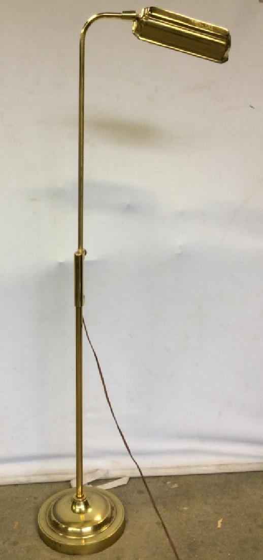 Gold Toned Adjustable Floor Lamp: Lamp is gold toned, possibly brass. Lamp has bent arm, circular base and height adjustable arm. Measures approx 10 inches wide 54 inches tall when arm is at highest point. Floor lamp, lighting, home a