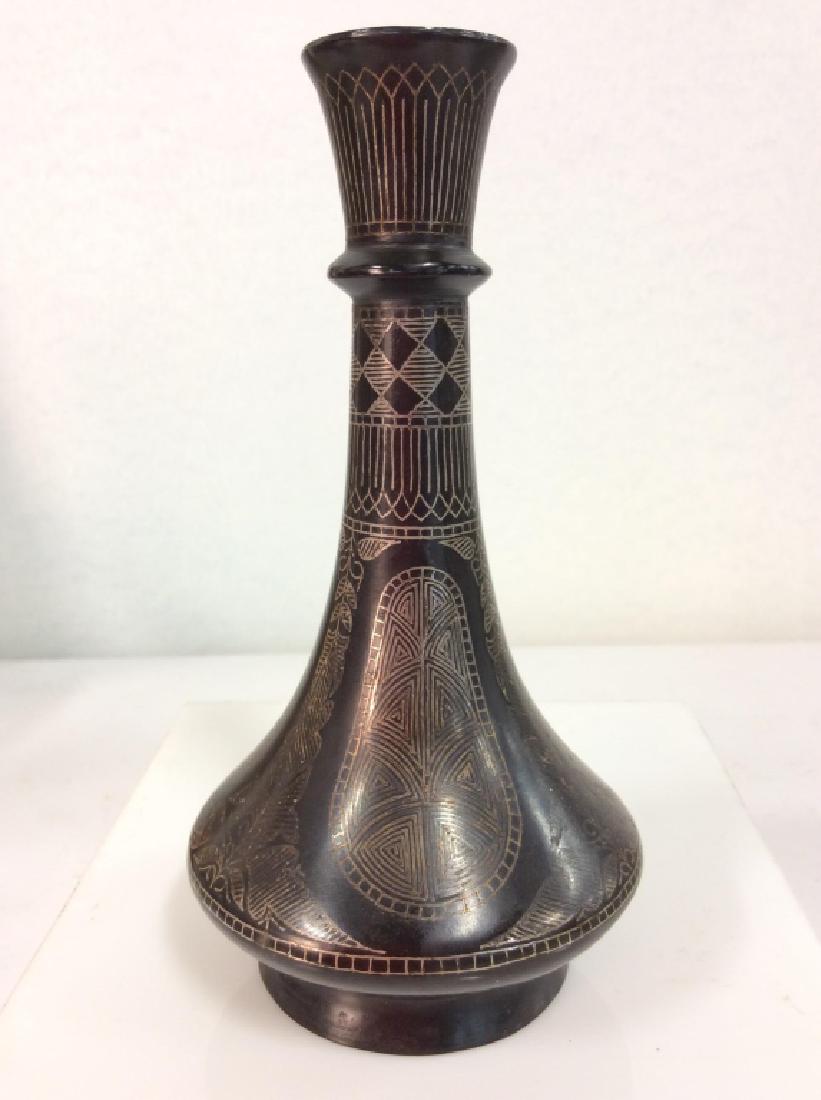 Indian Black Toned Metal Inlay Bud Vase: Indian Black Toned Metal Inlay Bud Vase. Black toned metal, wide base with thin fluted neck, silver toned metal floral and geometric line motif inlay design. Some minor surface wear and discoloration.