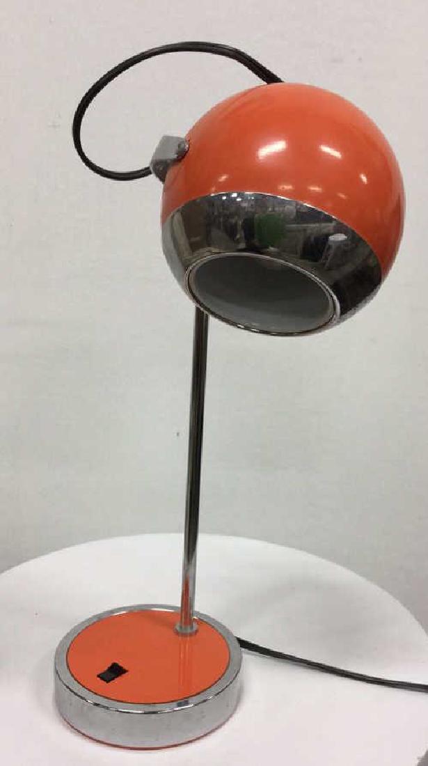 HAMILTON INDUSTRIES MidCentury Modern Lamp: HAMILTON INDUSTRIES MidCentury Modern Lamp. Model H 7. Orange toned with silver toned metal lamp with round metal moveable head. Measures approx 16 in tall by 7 in long by 5 in wide. Some minor surfac