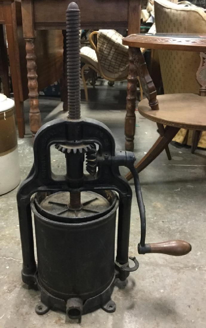 Vintage M.F.G CO Black Toned Metal Wine Press: Wine Press has wooden handled crank. Has not been tested. Has evident wear due to age. Measures approx 26 inches tall 15 inches wide. vintage appliance, kitchen accessory.